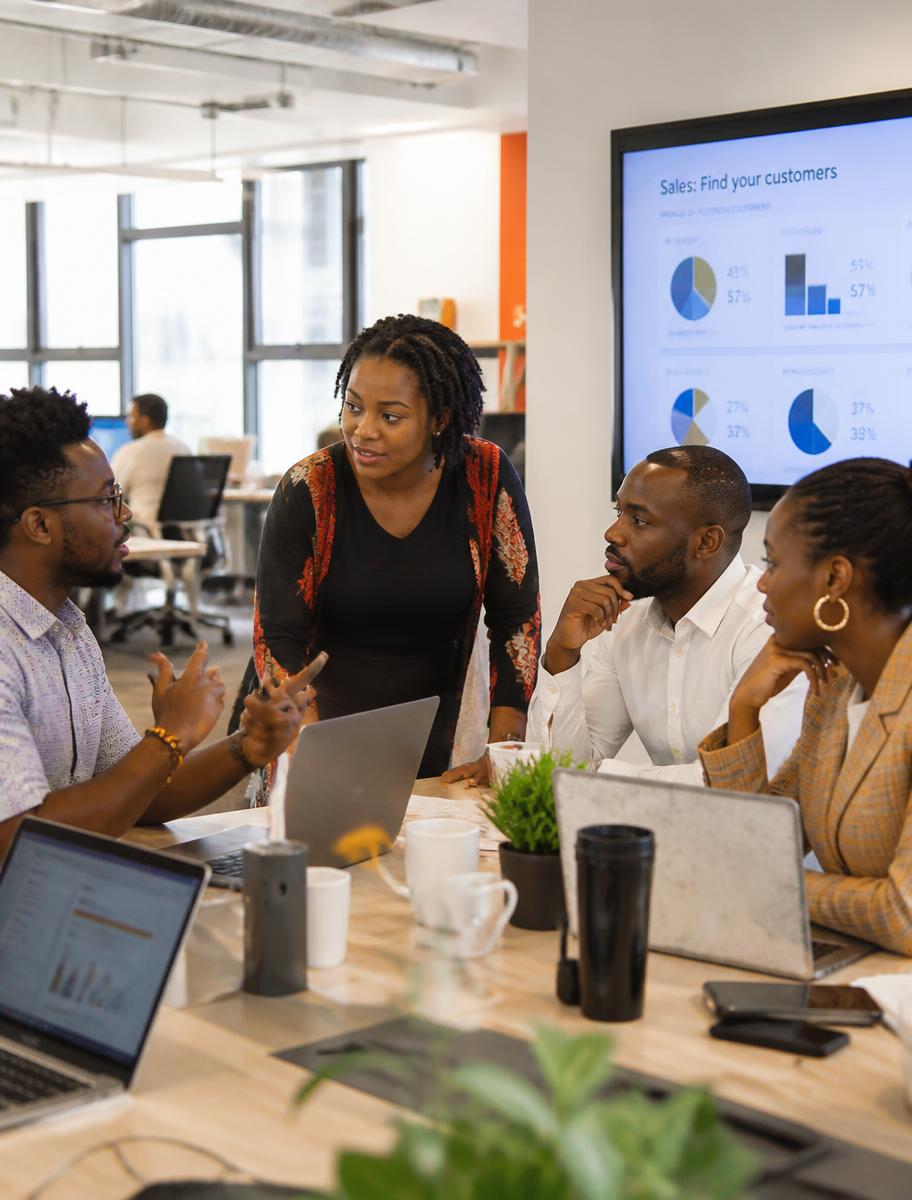 Enterprise team collaborating around laptops in an open plan office